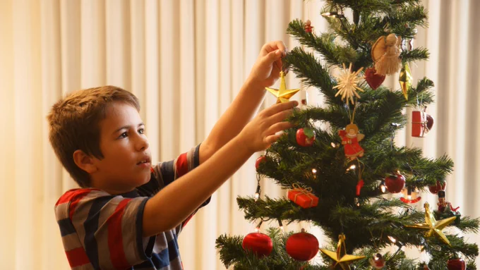 Child putting decorating's up on christmas tree