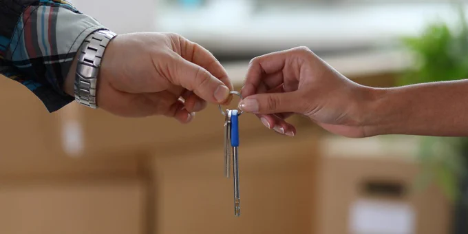 Male hand gives keys on ring to female hand