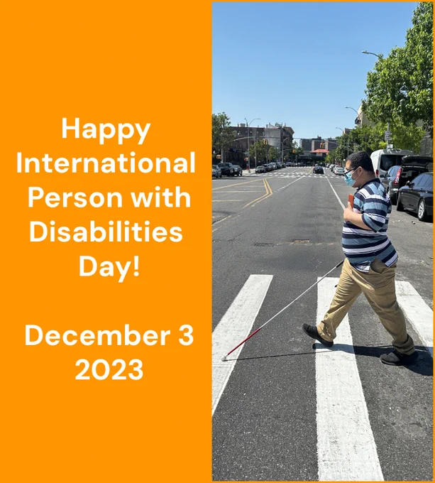A man crossing the street using oko. Orange square next ot the image with white text "Happy International Person with Disabilities Day! | December 3, 2023"