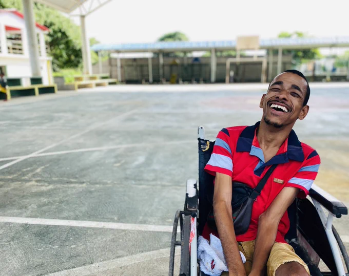 A man on a wheelchair smiling