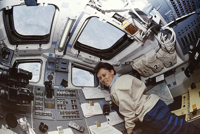 Dr. Roberta Bondar aboard Space Shuttle Discovery. We can see planet Earth outside the window.