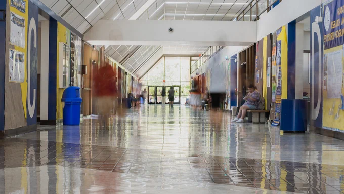DDH with blurred images of students walking through building