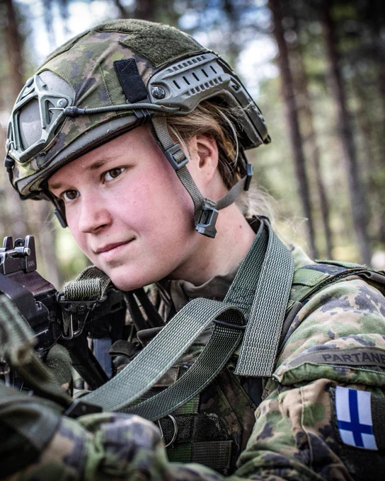 Finnish conscript looks down her weapon sights during exercise Northern Forest.