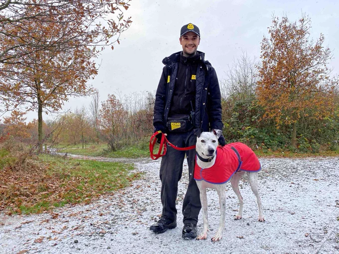 Rocket the dog is standing next to his carer.