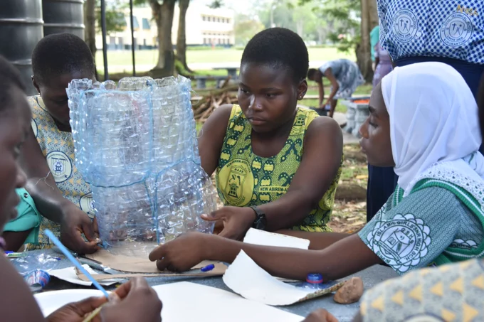 The students using plastic bottles to make waste bins.
