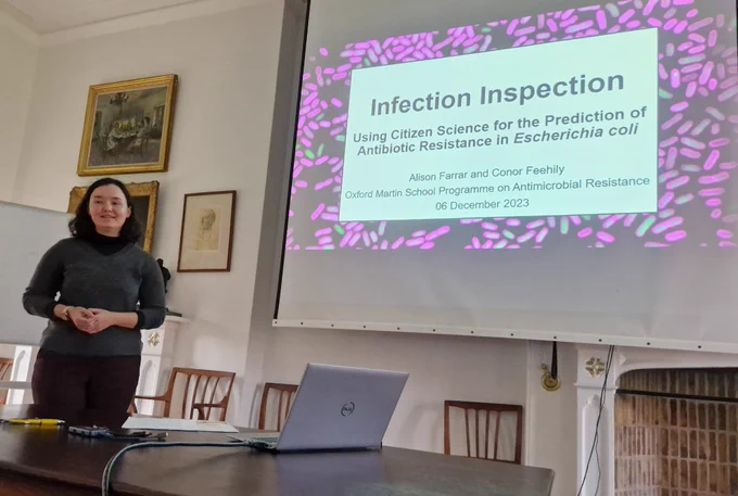 Researcher in front of a presentation entitled "Infection Inspection"