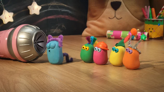 The Very Small Creatures are standing around in costumes watching Blue (dressed as a cat) singing into a microphone