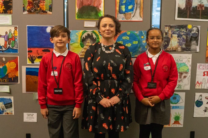 Catherine McKinnell MP with two young people standing in front of artwork. 