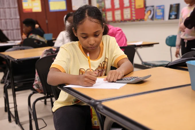 Photo of a student with calculator.