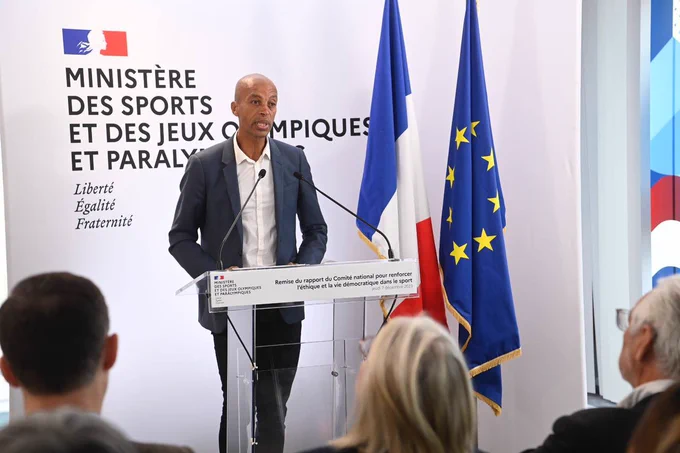 Photo de Stéphane Diagana debout derrière un pupitre s’adressant au public