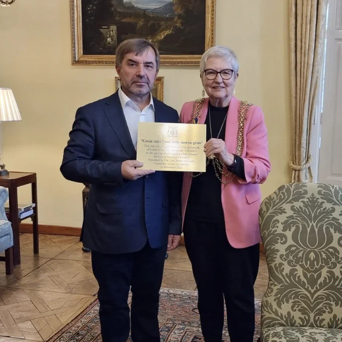 Lord Mayor of Leeds, Councillor Al Garthwaite, and the First Deputy Mayor of Kharkiv, Oleksander Novak, posing for a photo whilst holding the Friendship Oath between them.