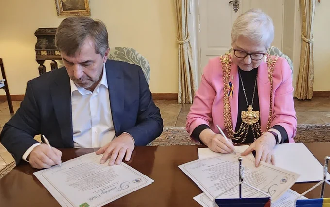 Lord Mayor of Leeds, Councillor Al Garthwaite, and the First Deputy Mayor of Kharkiv, Oleksander Novak, sat at a table signing the Friendship Oath.