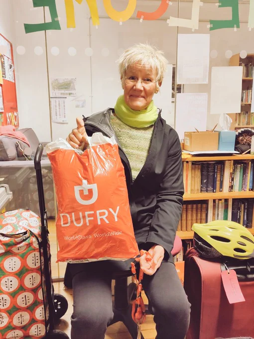 image of Hogets sitting in the Strand Chaplaincy Room with her donation of a warm winter jumper in hand.