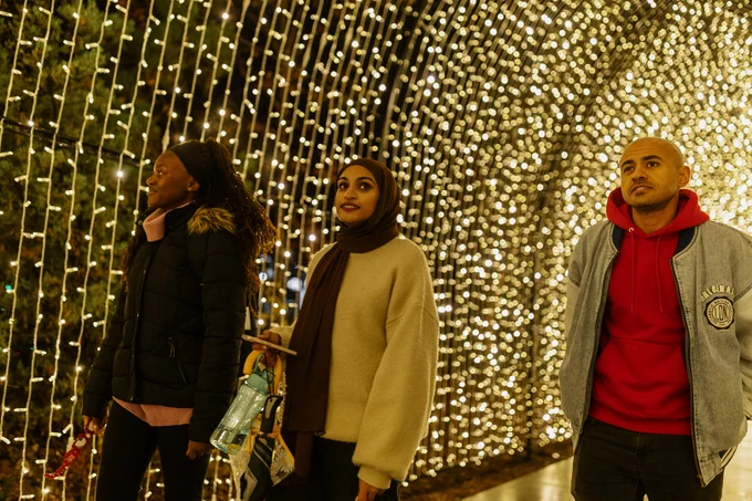 Students walk under an arch of lights at Zoo Lights