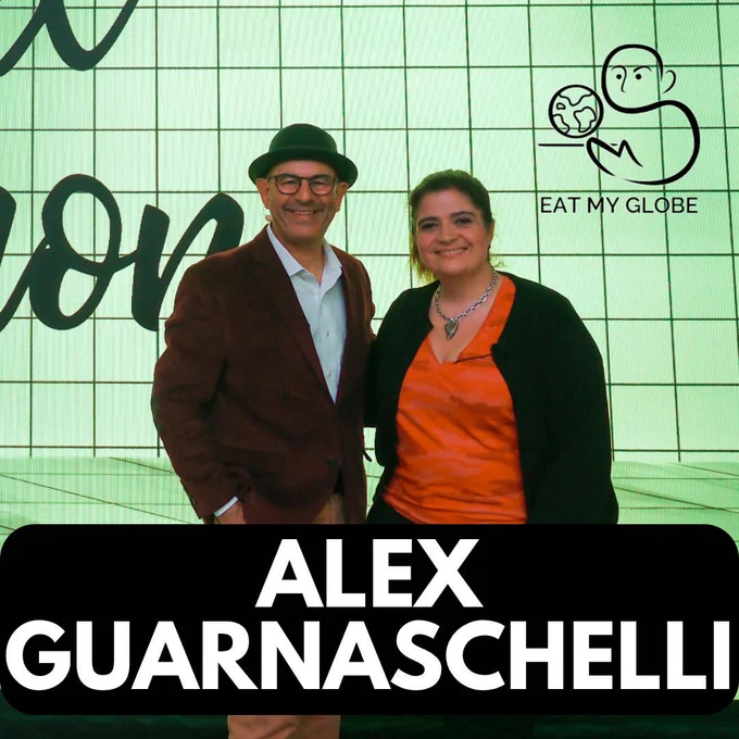 Simon Majumdar and Alex Guarnaschelli standing next to each other. Includes the text, “Alex Guarnaschelli.” Also includes the Eat My Globe logo of Simon Majumdar's likeness using the initials "S" and "M" holding a globe on a platter with the words, "Eat My Globe," underneath