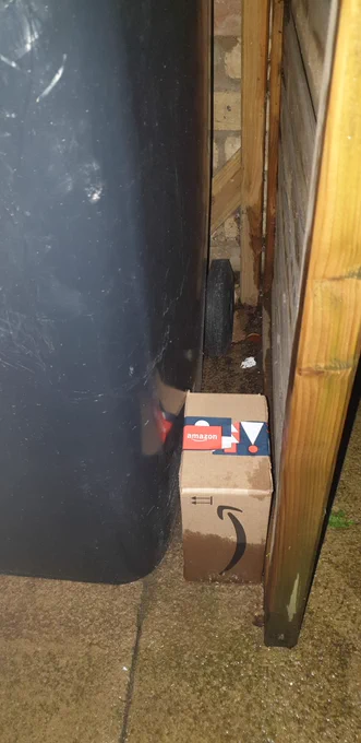 Soaked Amazon package placed next to bin in wet bin shed.
