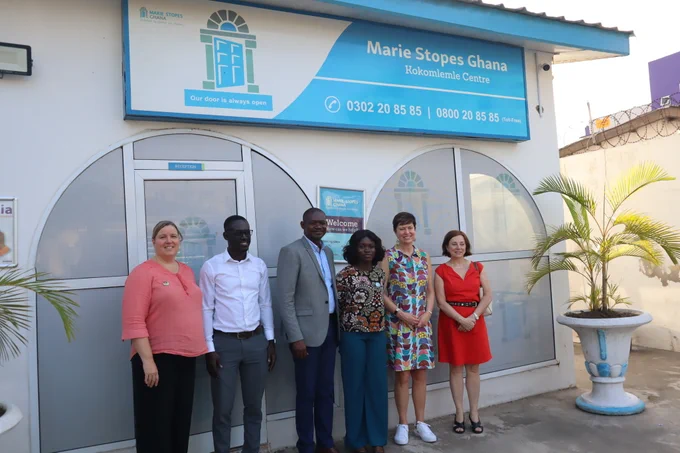 Parliamentary Secretary Damoff standing with staff of Marie Stopes Ghana.