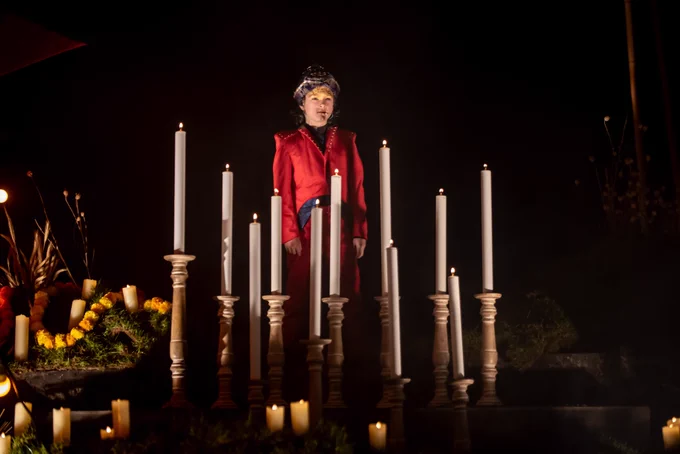 A child stood surrounded by candles.