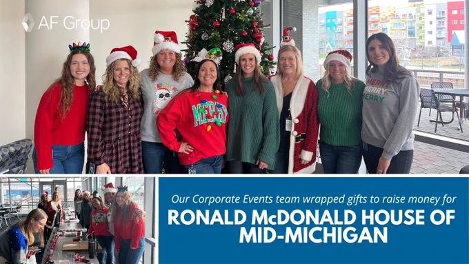 The Corporate Events team in front of a holiday tree and wrapping gifts at long tables