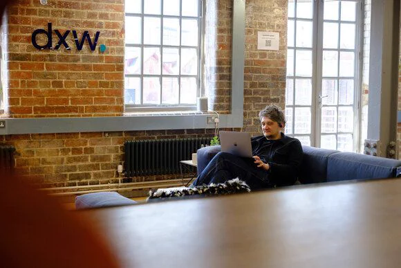 Chris sitting on the sofas next to the window in our Leeds office