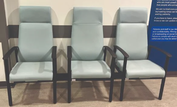 Three padded chairs with black frames, sitting in hospital waiting area.
