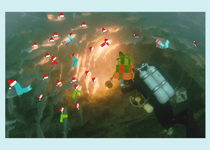 A diver swims with presents surrounding by fish that are wearing santa hats.
