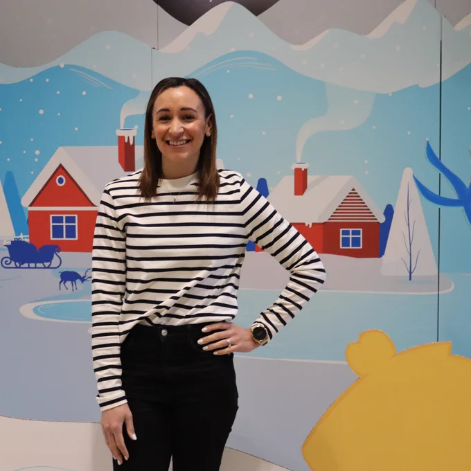 A female stands in an interactive winter wonderland scene.