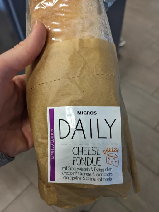 Foto von dem besten Sandwich der Welt mit der Aufschrift: "Cheese Fondue. Mit Silberzwiebeln und Essiggurken". Am Rand steht außerdem"Limited Edition ".