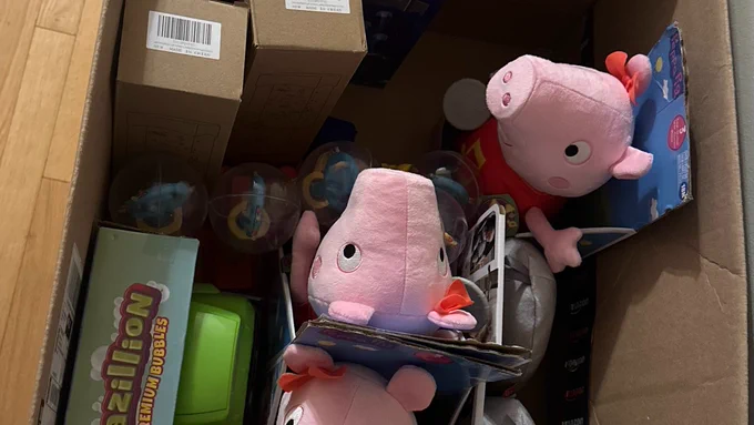 A box of adapted toys including Peppa Pig toys, bubble blower, light up wands and more