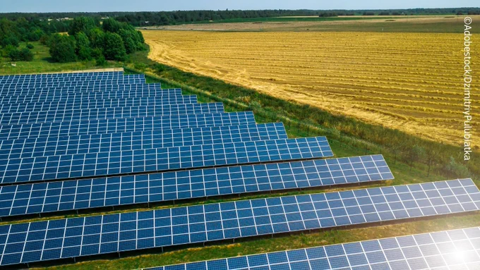 Fields with solar panels on the left and crops on the right. 