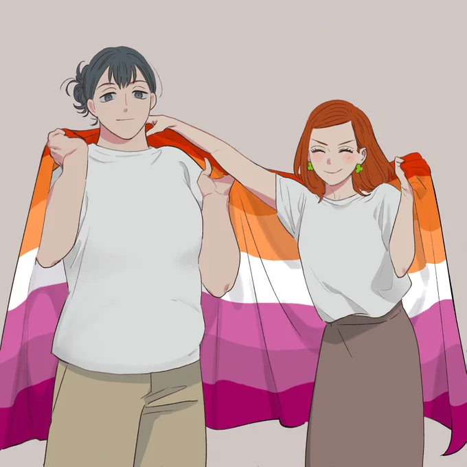 野本さんと春日さんが大きなレズビアンフラッグを背負っている