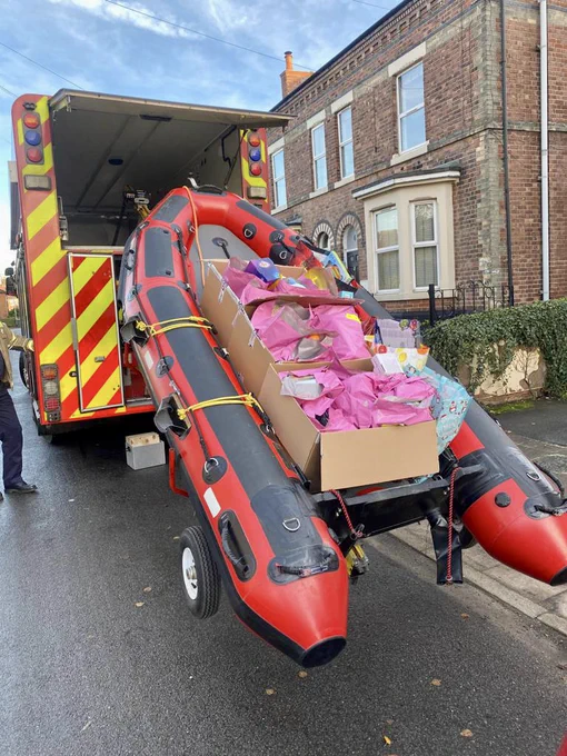 the Specialist Rescue Unit boat is lowered from the appliance, with boxes of presents in pink bags inside