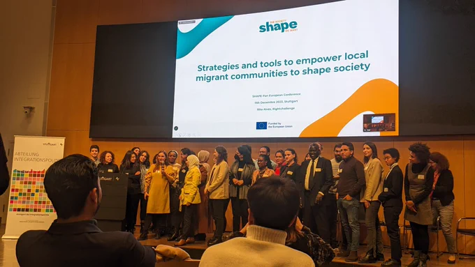 A group of 20 people standing on a stage