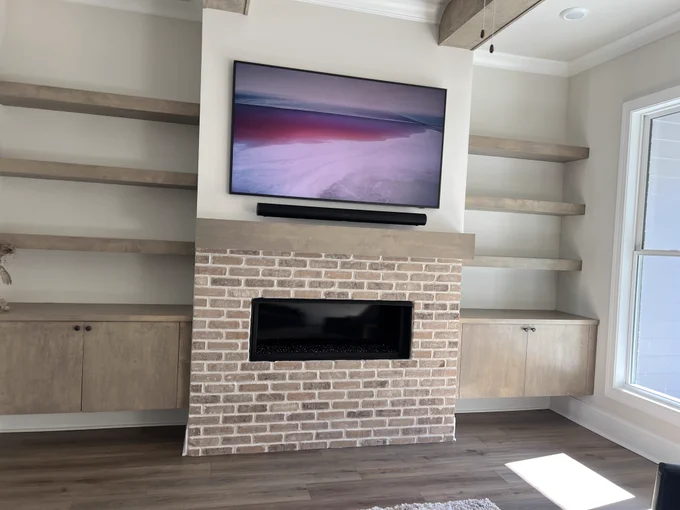 TV mounted above a Sonos speaker and fireplace.