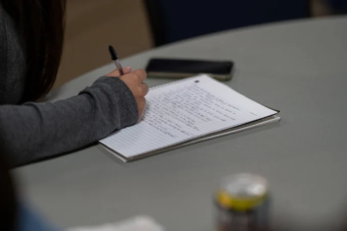 Image of student writing notes in notebook