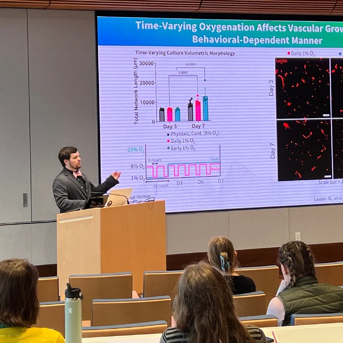 A grad student named Sam Lester gives a talk at a podium