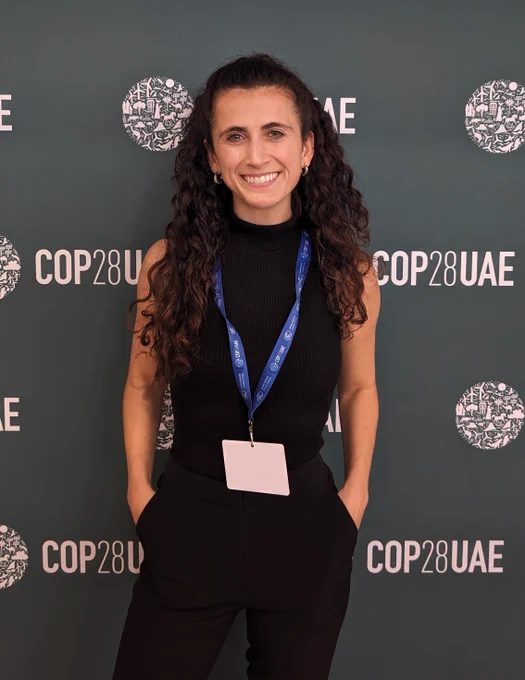 Student posing in front of COP28 UAE sign