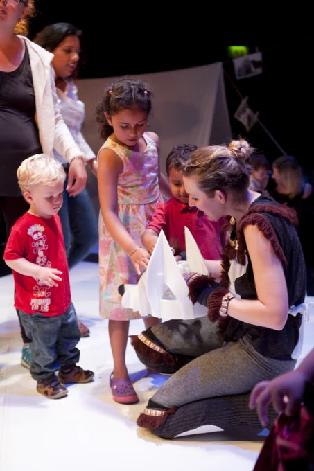 Photo of the performer with the husky puppet interacting with children audience members after the show, letting them pet the husky puppet. 