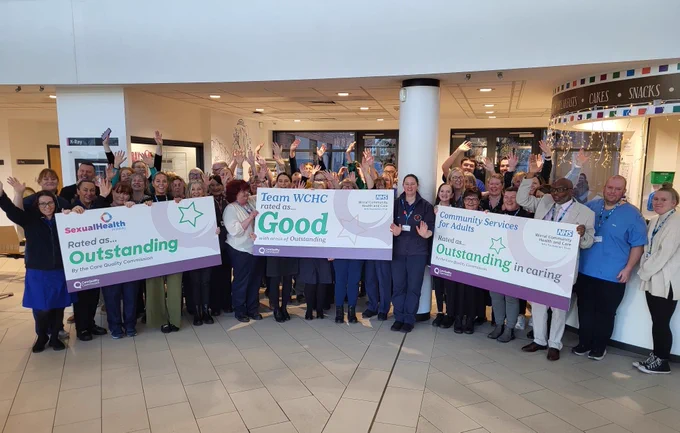Photograph of NHS staff holding banners: Sexual Health rated as Outstanding, Team WCHC rated as good and Community Services for Adults rated as Outstanding in caring. 