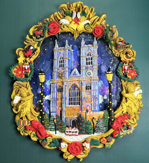 A painted clay medallion showing the West Towers of Westminster Abbey at Christmas time, with snow falling, Christmas trees outside the church and a group of choristers standing by the door. The medallion has a colourful boarder decorated with angels, bells and Christmas toys.