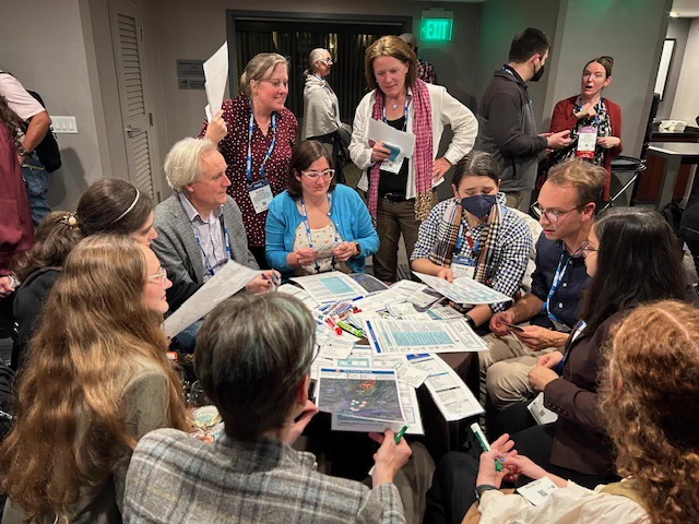 People gathered around a table working through a game together