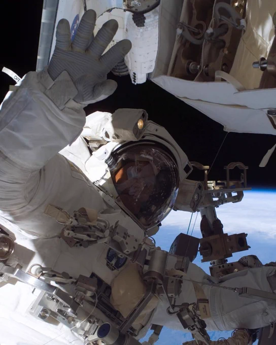 Dr. Steve MacLean waving during on a spacewalk.