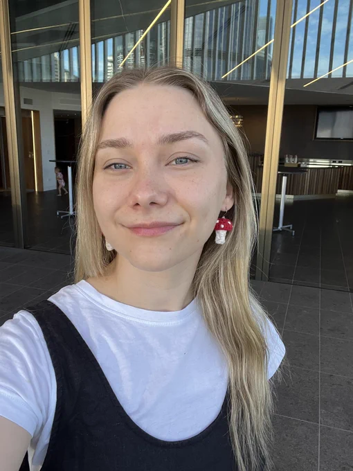 A photo of a white, blonde woman with crochet mushroom earrings.