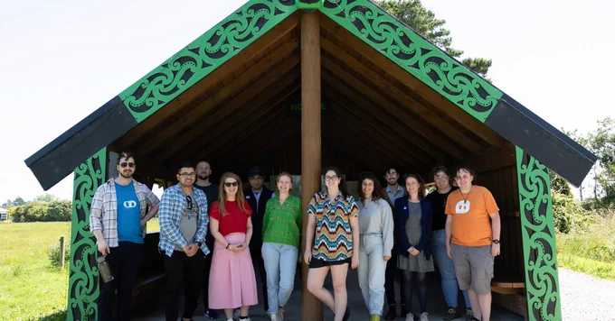 The CerebralFix Pounamu Pathway team standing at the entrance of the Ngahue Whare.