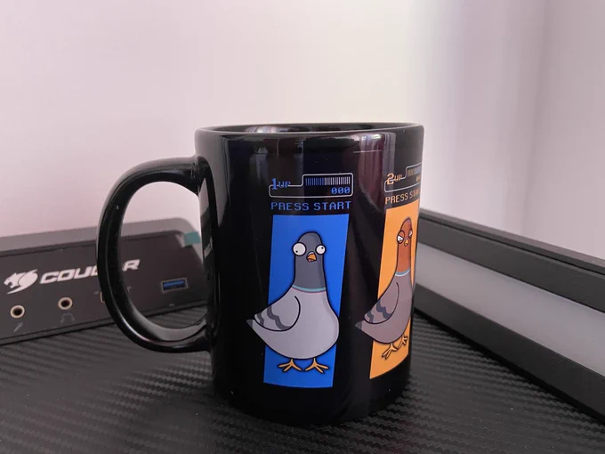 Image of a black cup with three pigeons on the center and right