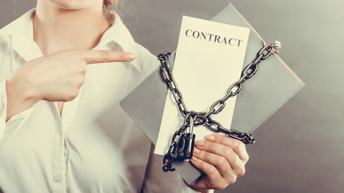 Woman in a white shirt pointing to a contract with a padlock and chain.
