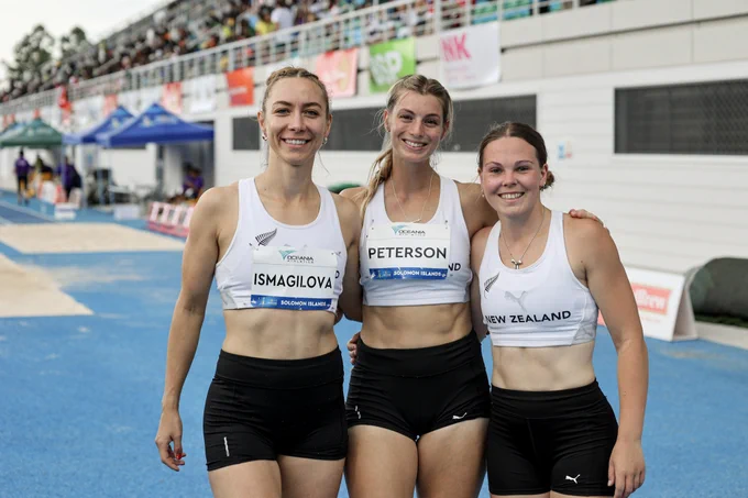Diana (left) smiling and posing with two team members at the 2023 Pacific Games in the Soloman Islands