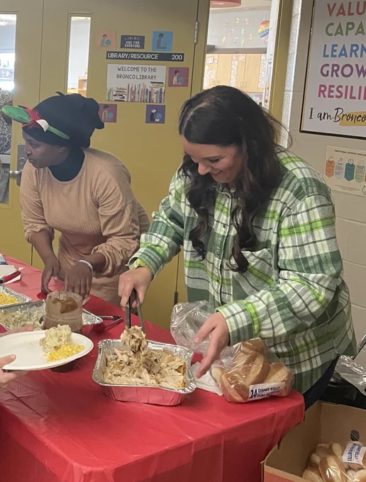 Volunteers serve food for a holiday lunch at Begley school