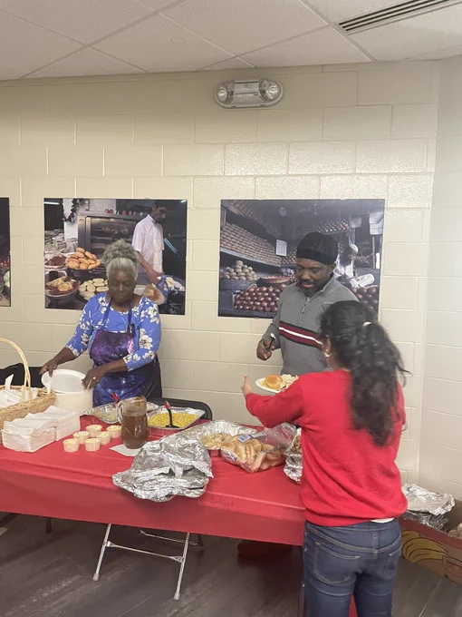 Volunteers serve food for a holiday lunch at Begley school