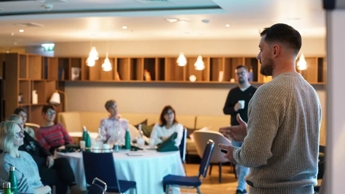 Man stood doing a talk to a room full of people
